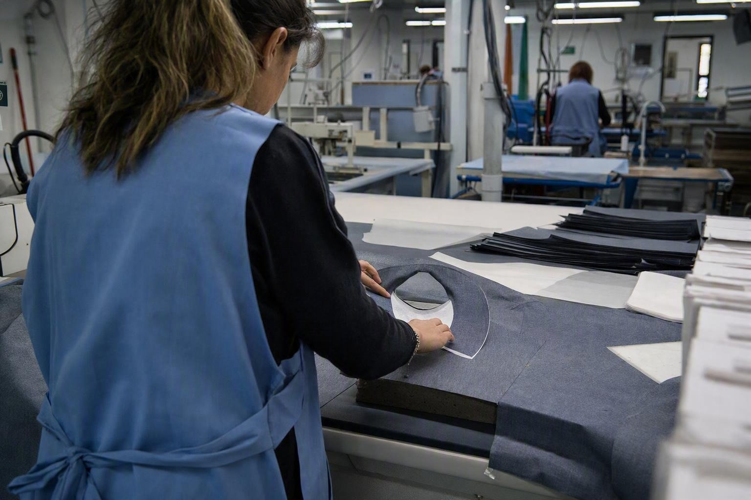 Contrôle d’un dessus de col thermocollé à plat, après refroidissement, avant assemblage et essai de lavage.